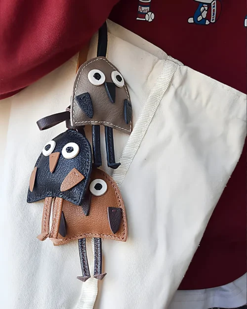 A playful bird bag charm handcrafted from French goatskin leather. Hand-stitched over three days and gift boxed for bags, keys, or car keys.