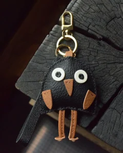 A playful bird bag charm handcrafted from French goatskin leather. Hand-stitched over three days and gift boxed for bags, keys, or car keys.