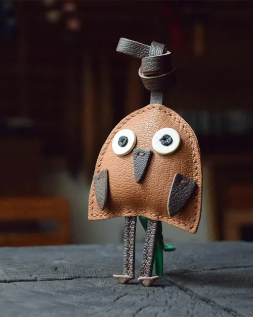 A playful bird bag charm handcrafted from French goatskin leather. Hand-stitched over three days and gift boxed for bags, keys, or car keys.