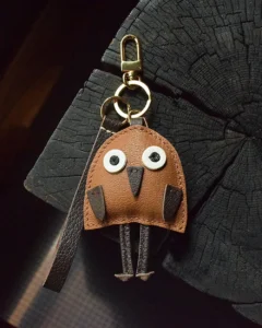 A playful bird bag charm handcrafted from French goatskin leather. Hand-stitched over three days and gift boxed for bags, keys, or car keys.