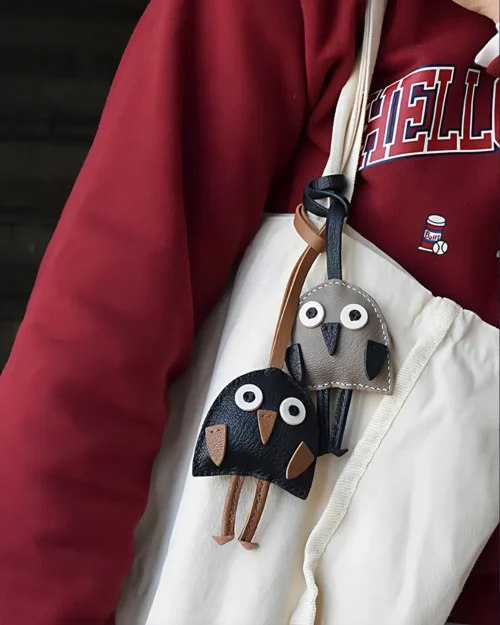 A playful bird bag charm handcrafted from French goatskin leather. Hand-stitched over three days and gift boxed for bags, keys, or car keys.