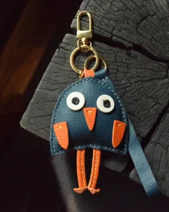 A playful bird bag charm handcrafted from French goatskin leather. Hand-stitched over three days and gift boxed for bags, keys, or car keys.