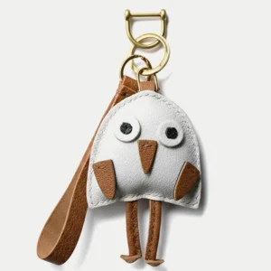 A playful bird bag charm handcrafted from French goatskin leather. Hand-stitched over three days and gift boxed for bags, keys, or car keys.