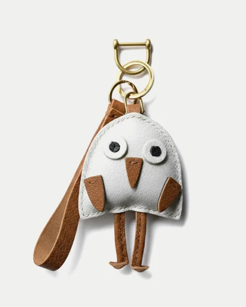 A playful bird bag charm handcrafted from French goatskin leather. Hand-stitched over three days and gift boxed for bags, keys, or car keys.