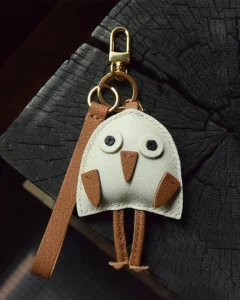 A playful bird bag charm handcrafted from French goatskin leather. Hand-stitched over three days and gift boxed for bags, keys, or car keys.