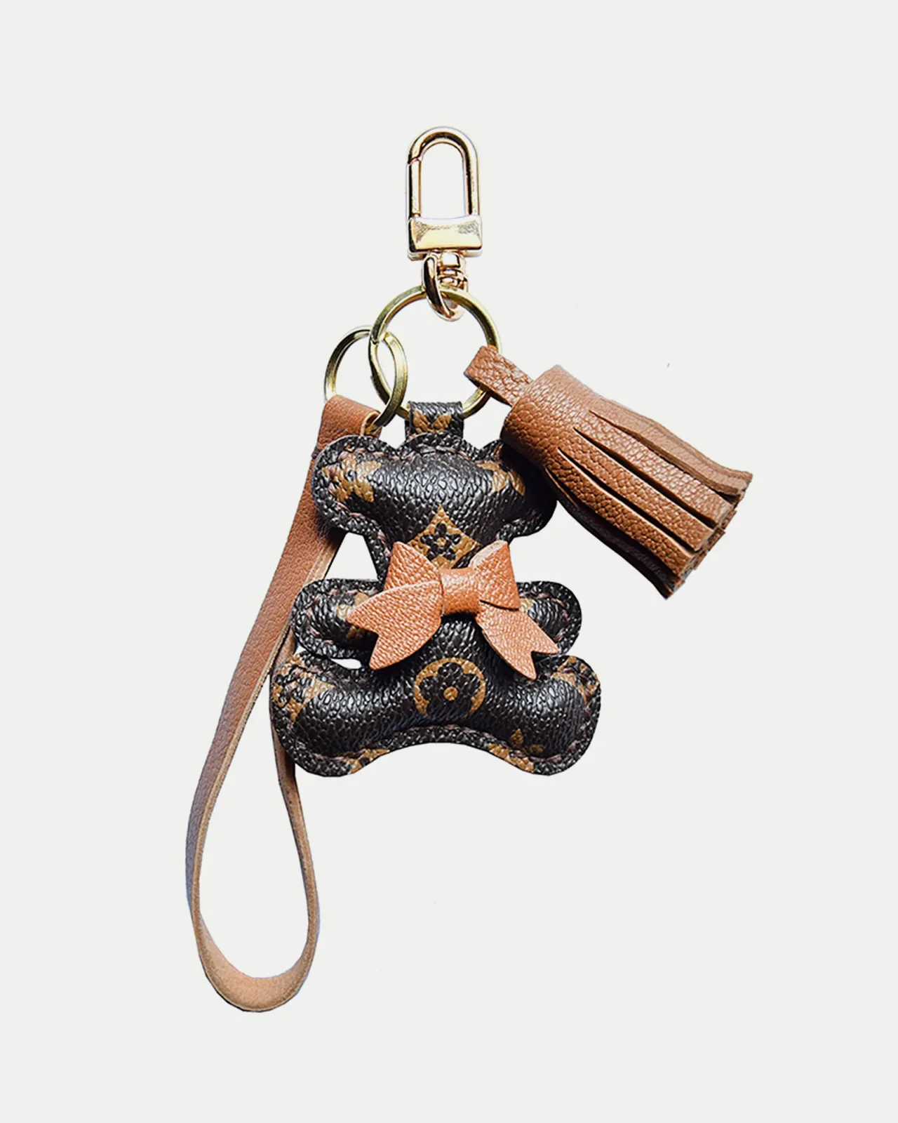 A playful bow bear bag charm handcrafted from French goatskin leather. Hand-stitched over three days and gift boxed for bags, keys, or car keys.