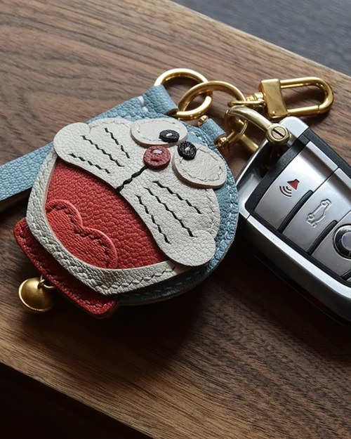 A playful Doraemon bag charm handcrafted from French goatskin leather. Hand-stitched over three days and gift boxed, perfect for bags, keys, or car keys.
