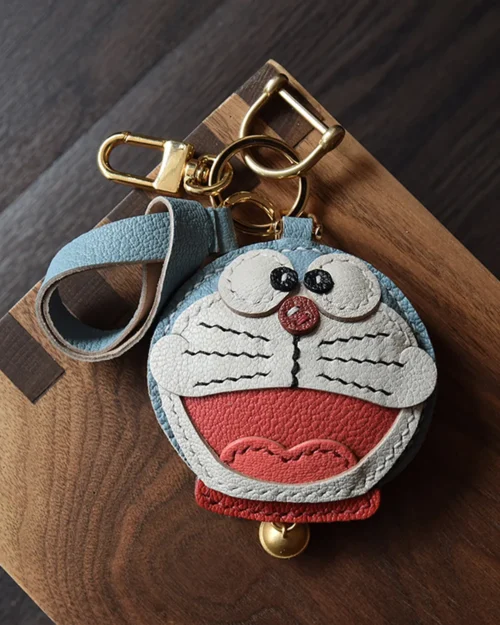 A playful Doraemon bag charm handcrafted from French goatskin leather. Hand-stitched over three days and gift boxed, perfect for bags, keys, or car keys.