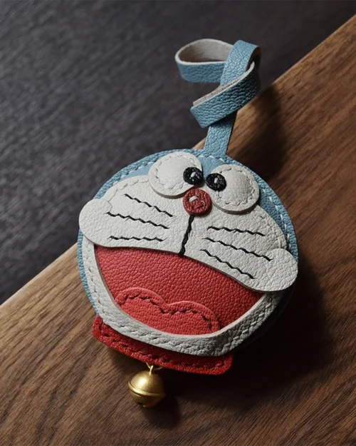 A playful Doraemon bag charm handcrafted from French goatskin leather. Hand-stitched over three days and gift boxed, perfect for bags, keys, or car keys.