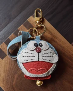 A playful Doraemon bag charm handcrafted from French goatskin leather. Hand-stitched over three days and gift boxed, perfect for bags, keys, or car keys.