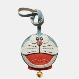 A playful Doraemon bag charm handcrafted from French goatskin leather. Hand-stitched over three days and gift boxed, perfect for bags, keys, or car keys.