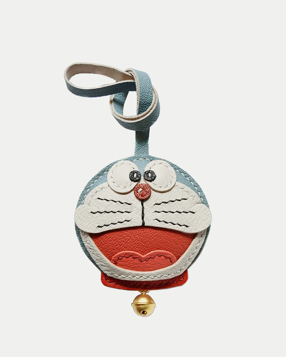 A playful Doraemon bag charm handcrafted from French goatskin leather. Hand-stitched over three days and gift boxed, perfect for bags, keys, or car keys.