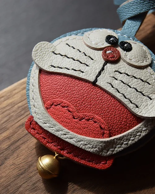 A playful Doraemon bag charm handcrafted from French goatskin leather. Hand-stitched over three days and gift boxed, perfect for bags, keys, or car keys.