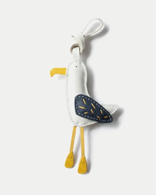 A whimsical seagull bag charm handcrafted from French goatskin leather. Hand-stitched over three days and gift boxed for bags, keys, or car keys.