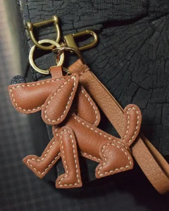 A playful dog bag charm handcrafted from French goatskin leather. Hand-stitched over three days and gift boxed, perfect for bags, keys, or car keys.