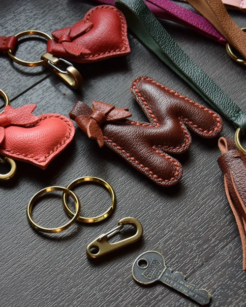 Keychain accessory components set featuring brass hardware, leather tassels, cords, and connectors for bag charms, keychains, and car key accessories.