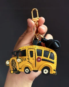 A cheerful school bus bag charm handcrafted from French goatskin leather. Hand-stitched over three days and gift boxed, ideal for bags, keys, or car keys.