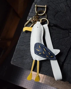 A whimsical seagull bag charm handcrafted from French goatskin leather. Hand-stitched over three days and gift boxed for bags, keys, or car keys.