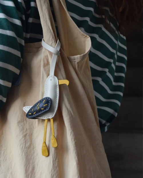 A whimsical seagull bag charm handcrafted from French goatskin leather. Hand-stitched over three days and gift boxed for bags, keys, or car keys.