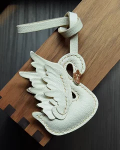 An elegant swan bag charm handcrafted from French goatskin leather. Hand-stitched over three days and gift boxed, ideal for bags, keys, or car keys.