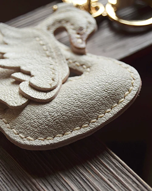 An elegant swan bag charm handcrafted from French goatskin leather. Hand-stitched over three days and gift boxed, ideal for bags, keys, or car keys.