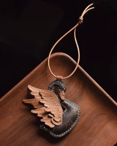 An elegant swan bag charm handcrafted from French goatskin leather. Hand-stitched over three days and gift boxed, ideal for bags, keys, or car keys.