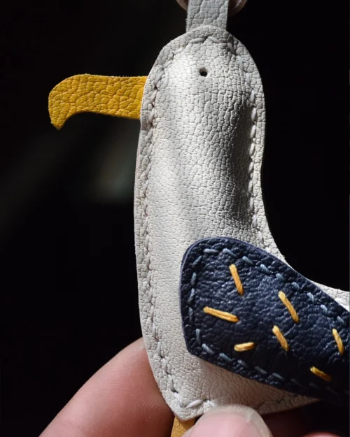 A whimsical seagull bag charm handcrafted from French goatskin leather. Hand-stitched over three days and gift boxed for bags, keys, or car keys.